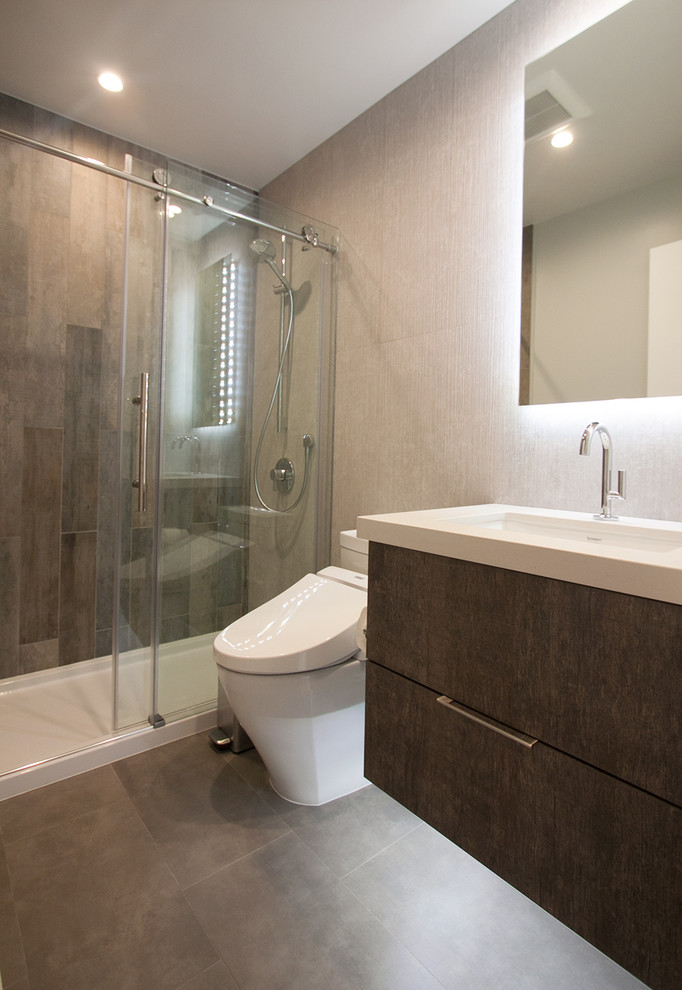Inspiration for a medium sized modern shower room bathroom in San Francisco with flat-panel cabinets, brown cabinets, an alcove shower, a one-piece toilet, multi-coloured tiles, porcelain tiles, grey walls, porcelain flooring, a submerged sink, engineered stone worktops, grey floors and a sliding door.