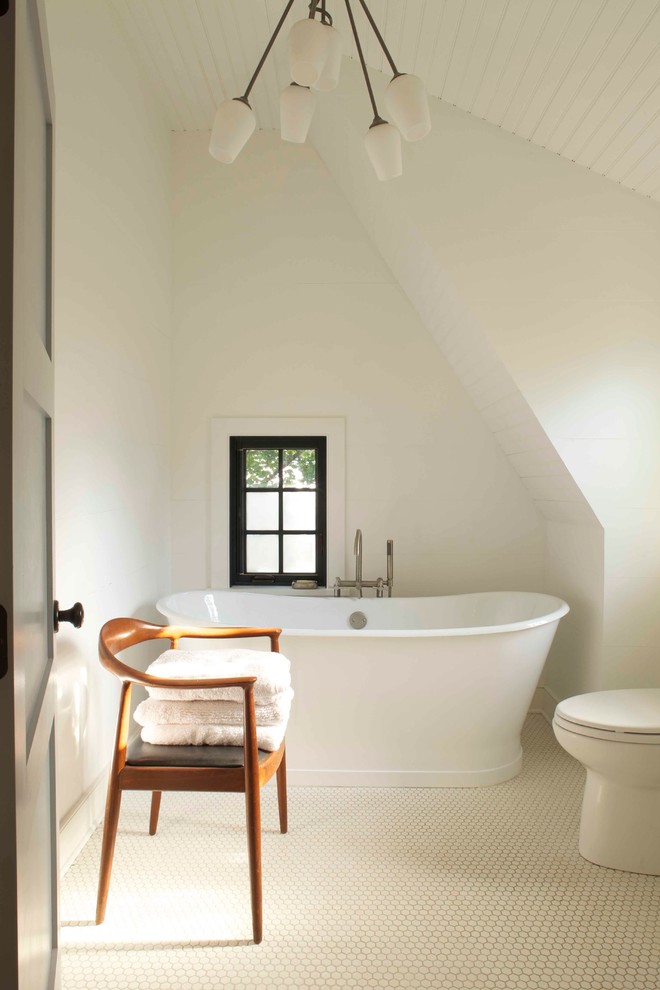 На фото: ванная комната в стиле кантри с отдельно стоящей ванной с