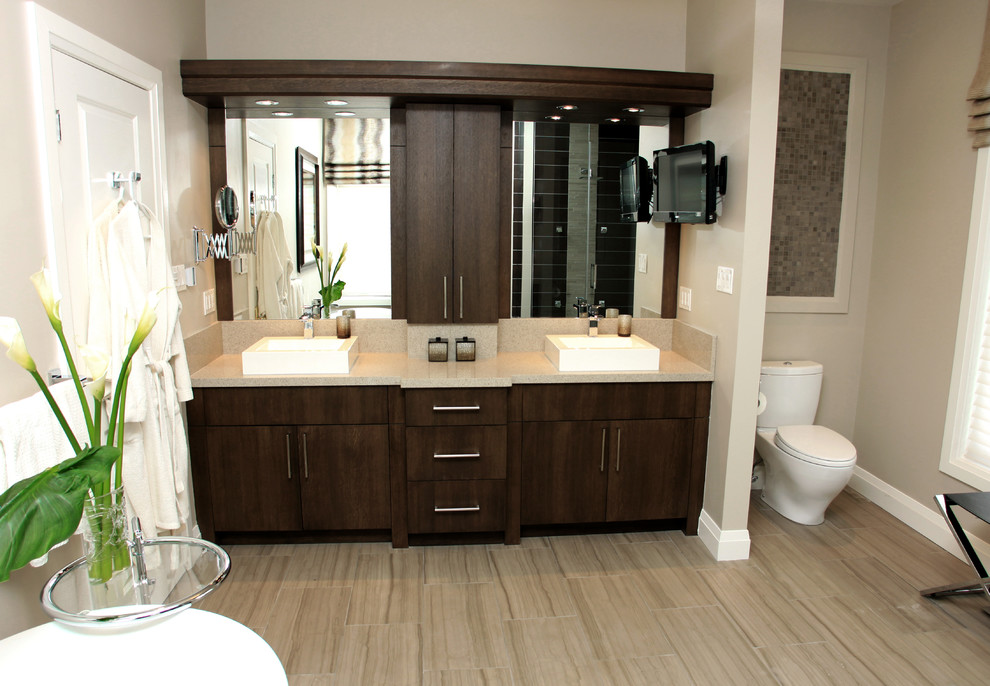 Design ideas for a large contemporary ensuite bathroom in Other with a vessel sink, flat-panel cabinets, medium wood cabinets, engineered stone worktops, a freestanding bath, a corner shower, a one-piece toilet, beige tiles, ceramic tiles, beige walls and ceramic flooring.