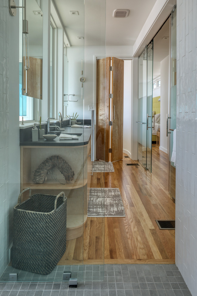 Cette photo montre une salle de bain principale moderne en bois clair de taille moyenne avec un placard à porte plane, un combiné douche/baignoire, un mur blanc, un sol en bois brun, un lavabo encastré, une cabine de douche à porte battante, meuble double vasque et meuble-lavabo encastré.