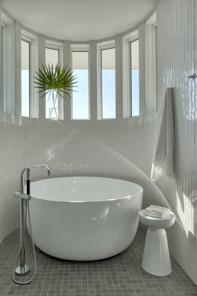 Foto på ett mellanstort maritimt en-suite badrum, med ett fristående badkar, grått golv, vit kakel och mosaikgolv