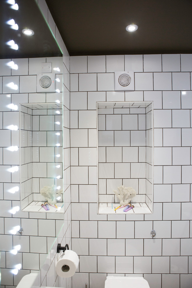 Example of a mid-sized kids' white tile and ceramic tile terrazzo floor and gray floor bathroom design in London with flat-panel cabinets, white walls and a hinged shower door