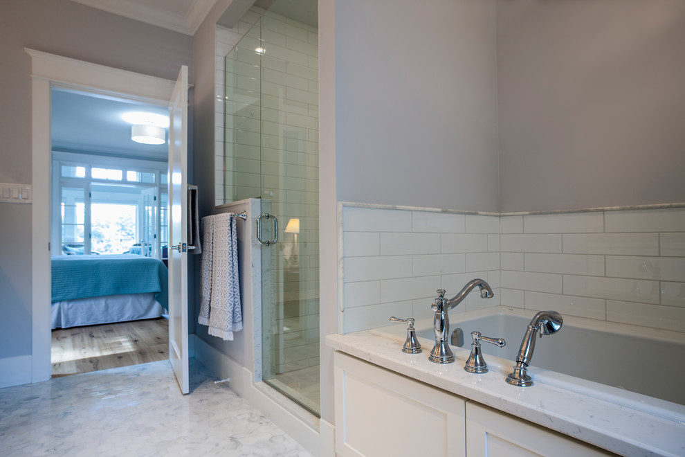 Klassisk inredning av ett mellanstort en-suite badrum, med skåp i shakerstil, vita skåp, ett badkar i en alkov, en hörndusch, vit kakel, tunnelbanekakel, marmorbänkskiva, dusch med gångjärnsdörr, grå väggar och grått golv