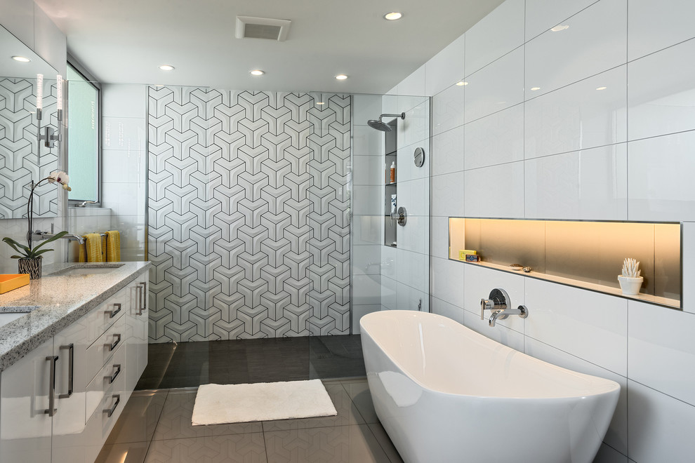 Inspiration för stora moderna en-suite badrum, med ett väggmonterat handfat, släta luckor, vita skåp, bänkskiva i kvartsit, ett fristående badkar, en kantlös dusch, en vägghängd toalettstol, vit kakel, vita väggar och klinkergolv i porslin