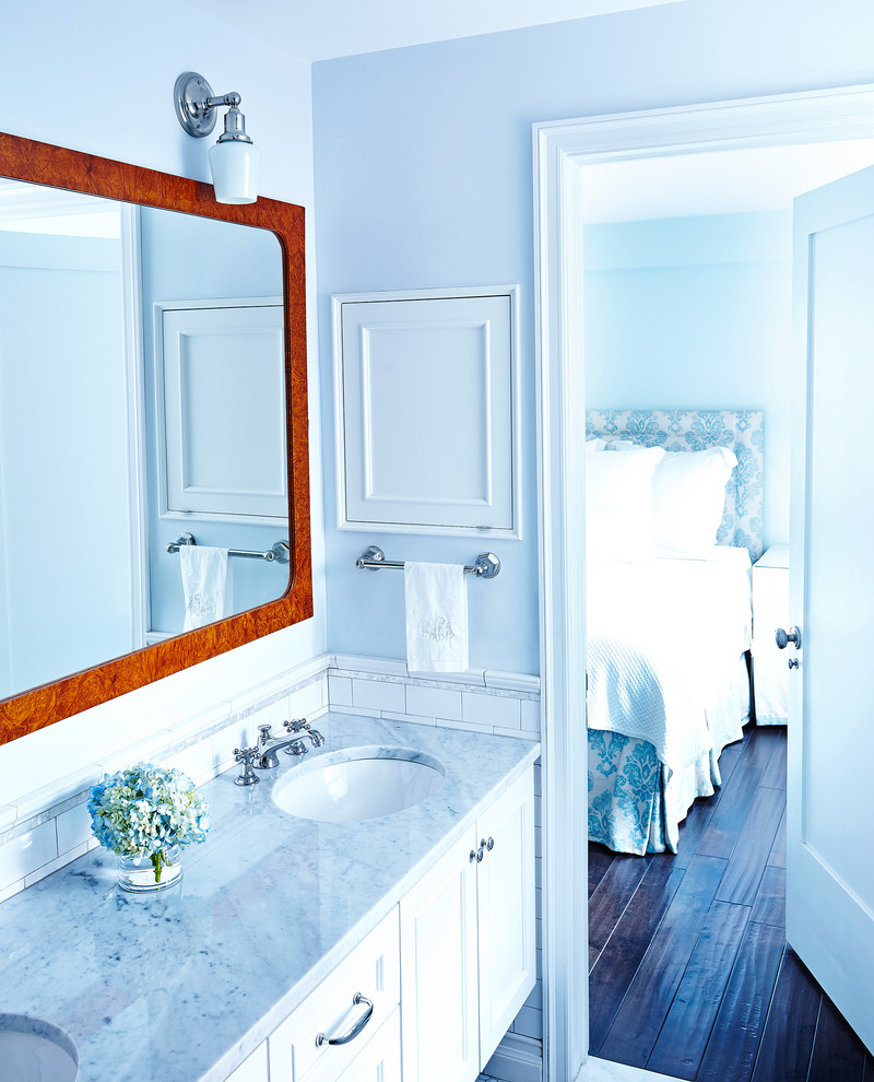 Aménagement d'une petite salle de bain principale classique avec un placard à porte shaker, des portes de placard blanches, un plan de toilette en marbre, un carrelage multicolore et un mur bleu.