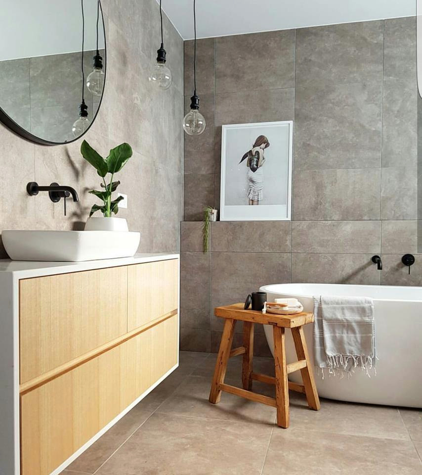 Exemple d'une salle de bain tendance en bois clair de taille moyenne avec une baignoire indépendante, un carrelage gris, un plan de toilette en quartz modifié et un plan de toilette blanc.