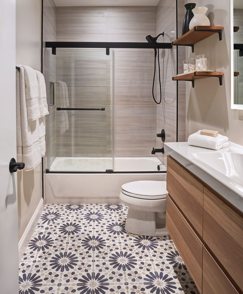 Идея дизайна: маленькая ванная комната в современном стиле с плоскими фасадами, светлыми деревянными фасадами, ванной в нише, душем над ванной, раздельным унитазом, серой плиткой, керамической плиткой, серыми стенами, полом из цементной плитки, подвесной раковиной, синим полом, душем с раздвижными дверями, белой столешницей, нишей, тумбой под одну раковину и подвесной тумбой для на участке и в саду