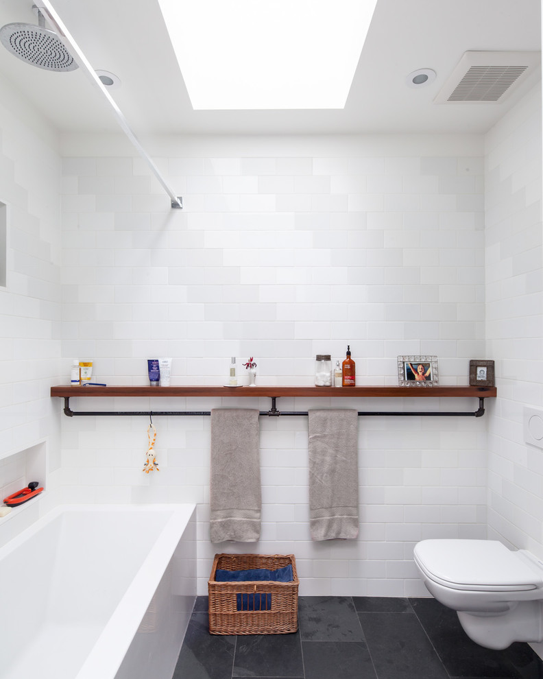 トロントにあるインダストリアルスタイルのおしゃれな浴室 (シャワー付き浴槽	、白いタイル) の写真