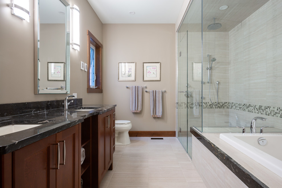 Inspiration for a large transitional master gray tile and travertine tile porcelain tile and gray floor bathroom remodel in Other with recessed-panel cabinets, medium tone wood cabinets, a one-piece toilet, beige walls, an undermount sink, granite countertops and gray countertops