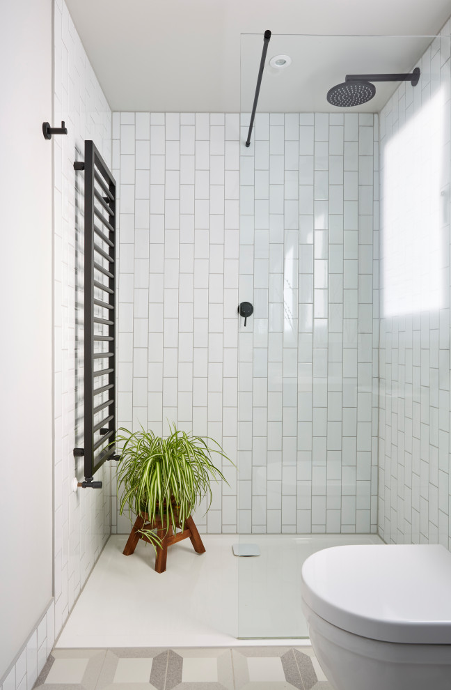 Inredning av ett modernt mellanstort badrum med dusch, med släta luckor, grå skåp, en öppen dusch, en toalettstol med separat cisternkåpa, vit kakel, porslinskakel, vita väggar, klinkergolv i porslin, ett integrerad handfat, grått golv och med dusch som är öppen