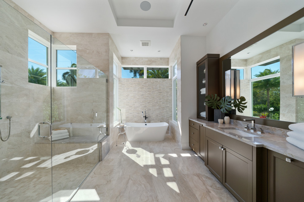 Inspiration for a contemporary ensuite bathroom in Miami with recessed-panel cabinets, brown cabinets, a freestanding bath, beige tiles, white walls, a submerged sink, beige floors, beige worktops, a single sink, a built in vanity unit and a drop ceiling.