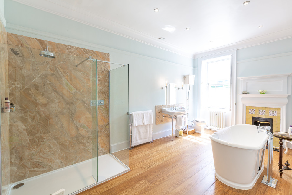Inspiration pour une salle de bain traditionnelle avec une baignoire indépendante, une douche d'angle, un mur bleu, un sol en bois brun, un plan vasque, un sol marron, aucune cabine et un plan de toilette blanc.