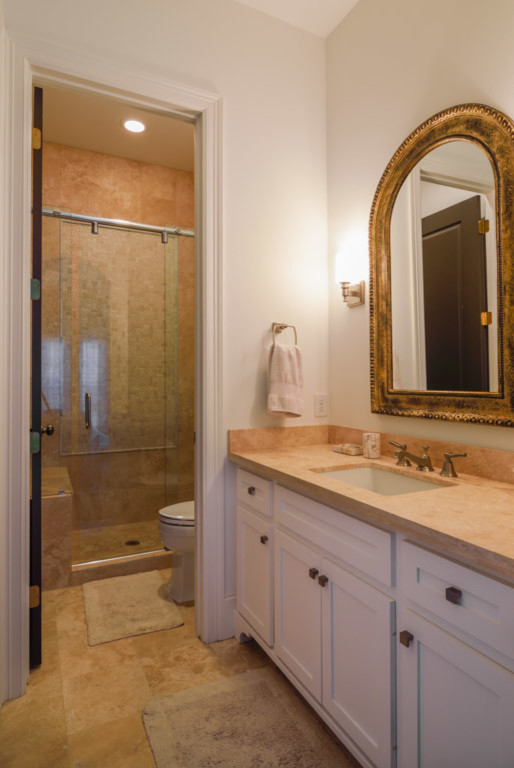 Inspiration för ett mellanstort vintage badrum, med ett undermonterad handfat, luckor med infälld panel, vita skåp, marmorbänkskiva, beige kakel, stenkakel, vita väggar och travertin golv