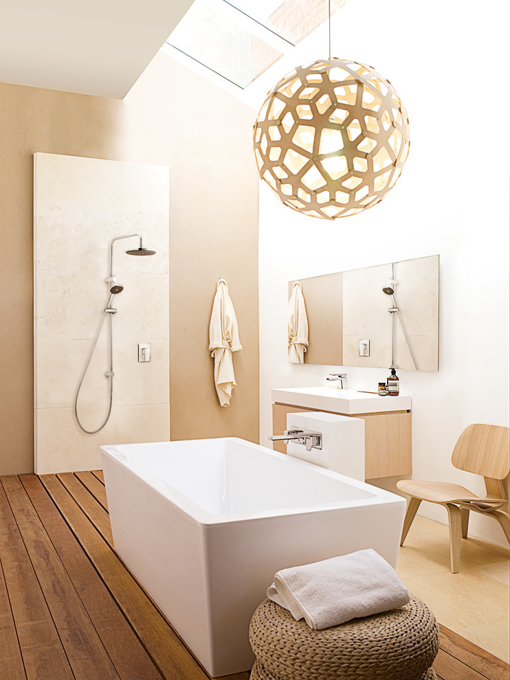 На фото: большая главная ванная комната в современном стиле с подвесной раковиной, отдельно стоящей ванной, открытым душем, плиткой из листового камня, белыми стенами, паркетным полом среднего тона и открытым душем с