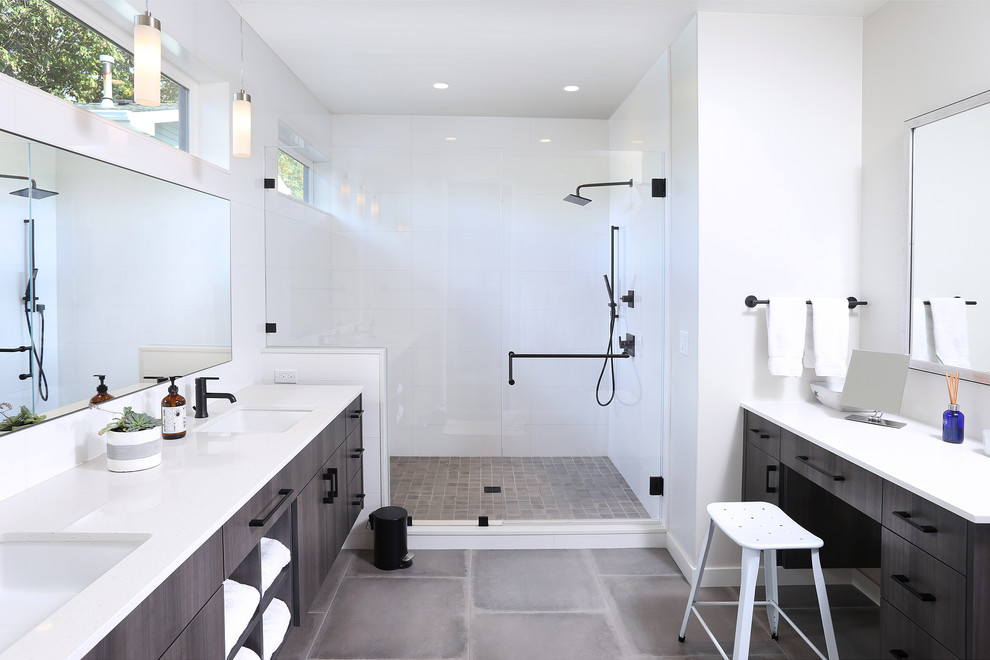 Design ideas for a large contemporary ensuite bathroom in Seattle with flat-panel cabinets, dark wood cabinets, white tiles, ceramic tiles, porcelain flooring, a submerged sink, engineered stone worktops, grey floors, white worktops, a corner shower, white walls and a hinged door.