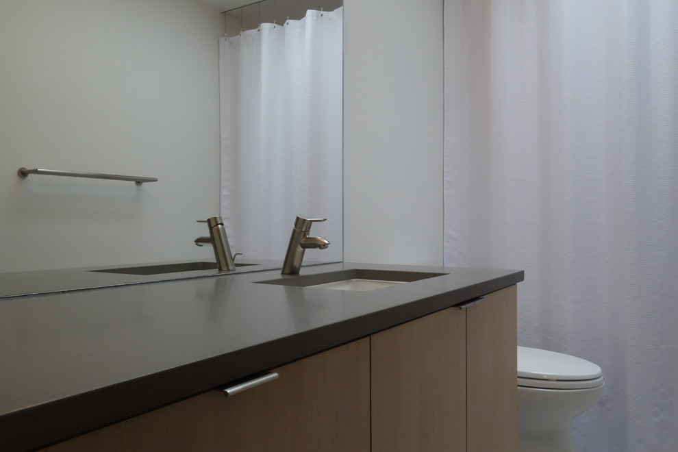 Modernes Badezimmer mit Unterbauwaschbecken, flächenbündigen Schrankfronten, Quarzwerkstein-Waschtisch, Wandtoilette mit Spülkasten und Vinylboden in Seattle