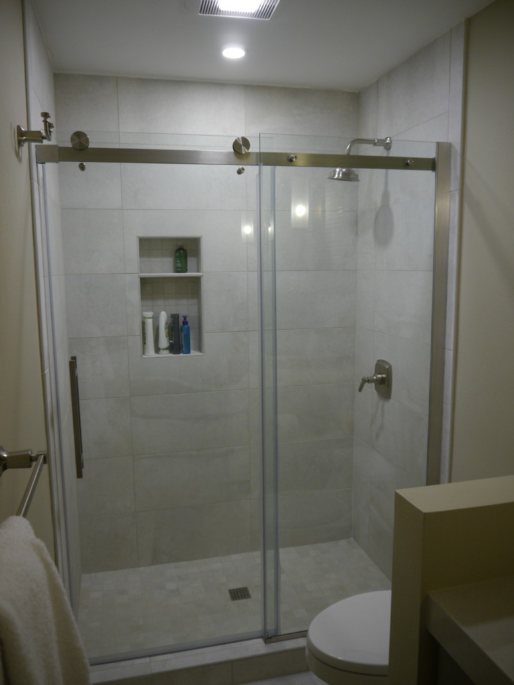 На фото: ванная комната среднего размера в стиле неоклассика (современная классика) с фасадами в стиле шейкер, зелеными фасадами, душем в нише, раздельным унитазом, серой плиткой, керамогранитной плиткой, бежевыми стенами, полом из керамогранита, душевой кабиной, врезной раковиной, столешницей из искусственного кварца, серым полом, душем с раздвижными дверями и бежевой столешницей