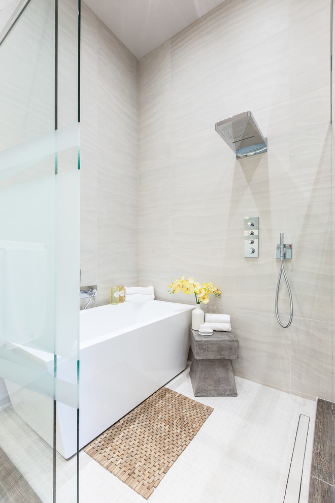 Imagen de cuarto de baño actual con bañera exenta, ducha empotrada y baldosas y/o azulejos grises