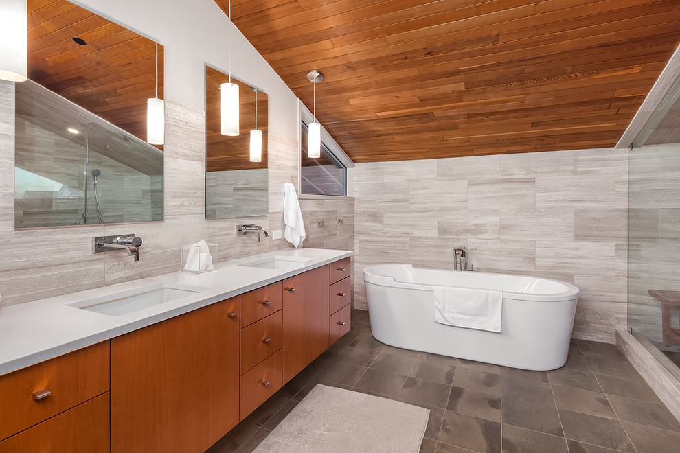 Großes Modernes Badezimmer En Suite mit flächenbündigen Schrankfronten, hellbraunen Holzschränken, freistehender Badewanne, offener Dusche, grauen Fliesen, Porzellanfliesen, grauer Wandfarbe, Unterbauwaschbecken und Quarzwerkstein-Waschtisch in Seattle