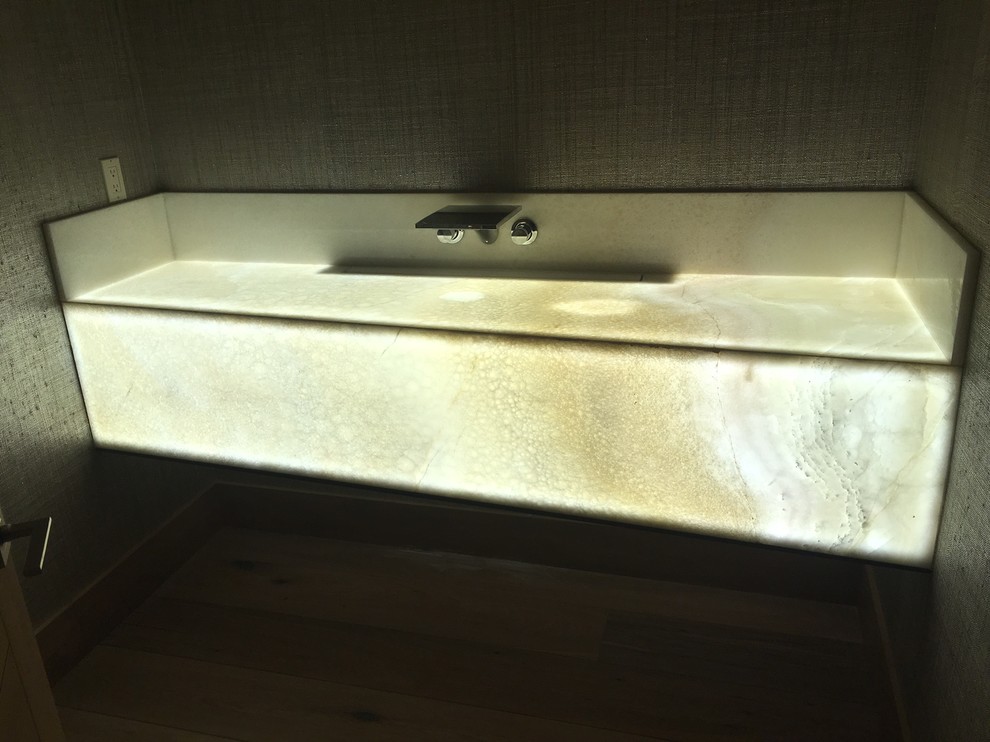 Foto di una stanza da bagno con doccia con parquet chiaro, lavabo integrato e top in onice