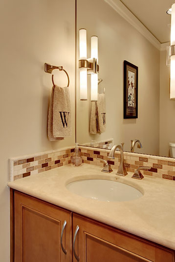 Aménagement d'une salle de bain classique en bois brun de taille moyenne avec un placard à porte affleurante, un carrelage beige, mosaïque, un mur beige, parquet en bambou, un lavabo encastré et un plan de toilette en calcaire.