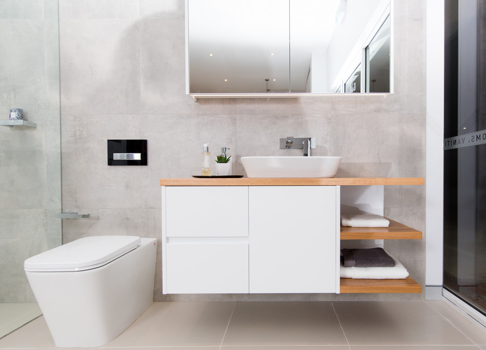 Modernes Badezimmer mit flächenbündigen Schrankfronten, weißen Schränken, grauen Fliesen, Zementfliesen, grauer Wandfarbe, Aufsatzwaschbecken und Waschtisch aus Holz in Sydney