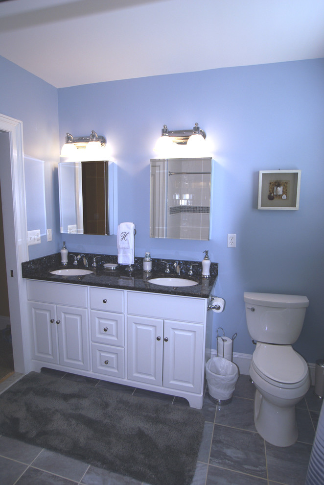 Idée de décoration pour une salle d'eau tradition de taille moyenne avec un placard avec porte à panneau surélevé, des portes de placard blanches, WC à poser, un mur bleu, un sol en carrelage de céramique, un lavabo encastré et un plan de toilette en surface solide.