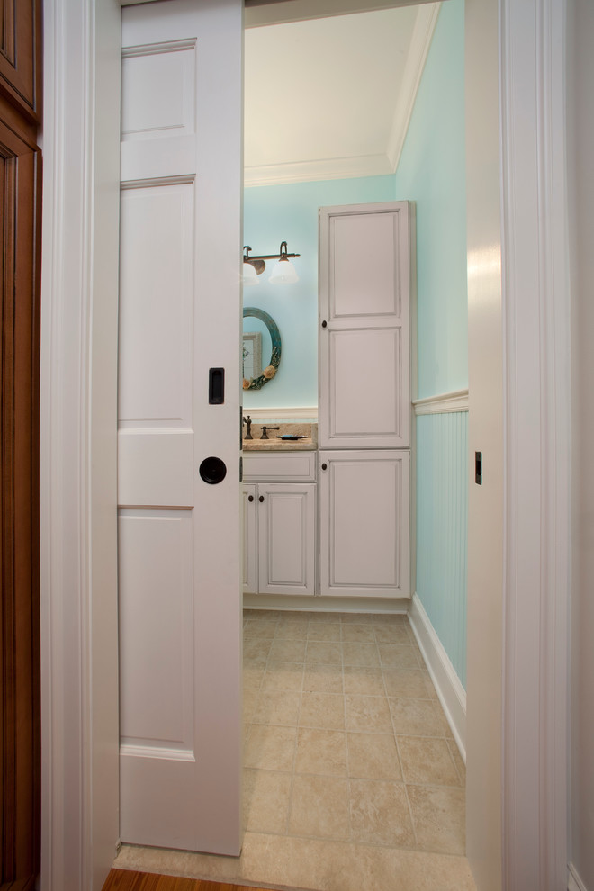 Photo of a small traditional shower room bathroom in Philadelphia with raised-panel cabinets, white cabinets, a walk-in shower, a two-piece toilet, beige tiles, ceramic tiles, blue walls, ceramic flooring, a submerged sink and granite worktops.