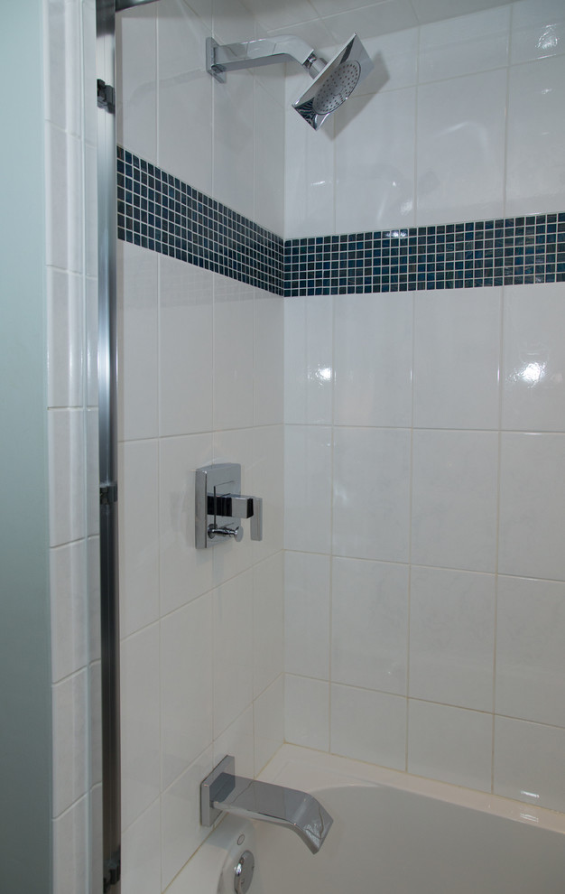 Klassisk inredning av ett mellanstort en-suite badrum, med ett undermonterad handfat, släta luckor, en dusch/badkar-kombination, en toalettstol med separat cisternkåpa, blå väggar, skåp i mörkt trä, granitbänkskiva och vit kakel
