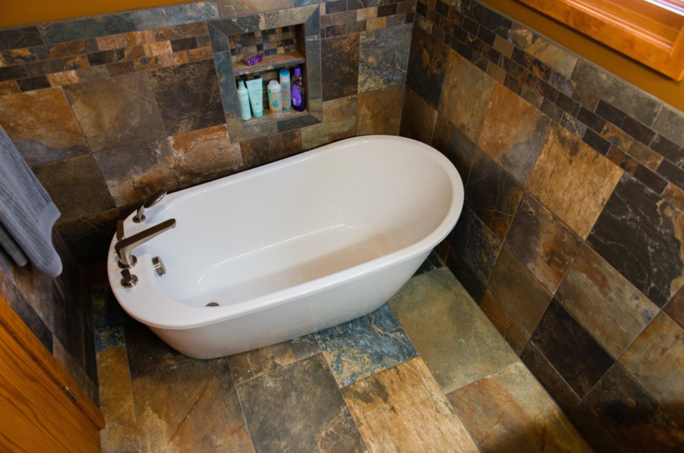 Klassisk inredning av ett mellanstort en-suite badrum, med ett fristående badkar, beige kakel, svart kakel, brun kakel, grå kakel, stenkakel, bruna väggar, skiffergolv och flerfärgat golv