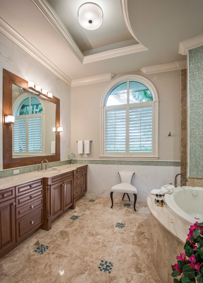 Inredning av ett klassiskt mellanstort en-suite badrum, med luckor med upphöjd panel, skåp i mörkt trä, ett platsbyggt badkar, grå kakel, stickkakel, beige väggar, travertin golv, ett undermonterad handfat och marmorbänkskiva