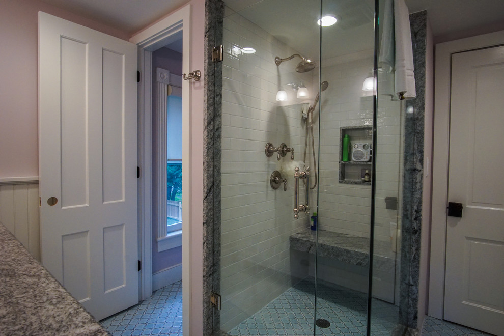 Пример оригинального дизайна: ванная комната среднего размера в стиле неоклассика (современная классика) с белыми фасадами, угловым душем, розовыми стенами, врезной раковиной, столешницей из гранита, полом из керамической плитки, унитазом-моноблоком, плиткой кабанчик, разноцветной столешницей, белой плиткой, душевой кабиной, душем с распашными дверями и фасадами с утопленной филенкой