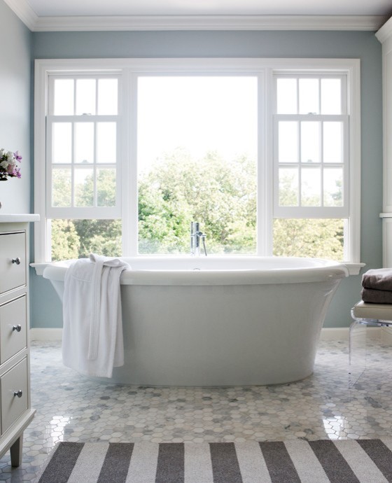 Inspiration for a mid-sized timeless 3/4 mosaic tile floor freestanding bathtub remodel in New York with flat-panel cabinets, white cabinets, blue walls and solid surface countertops