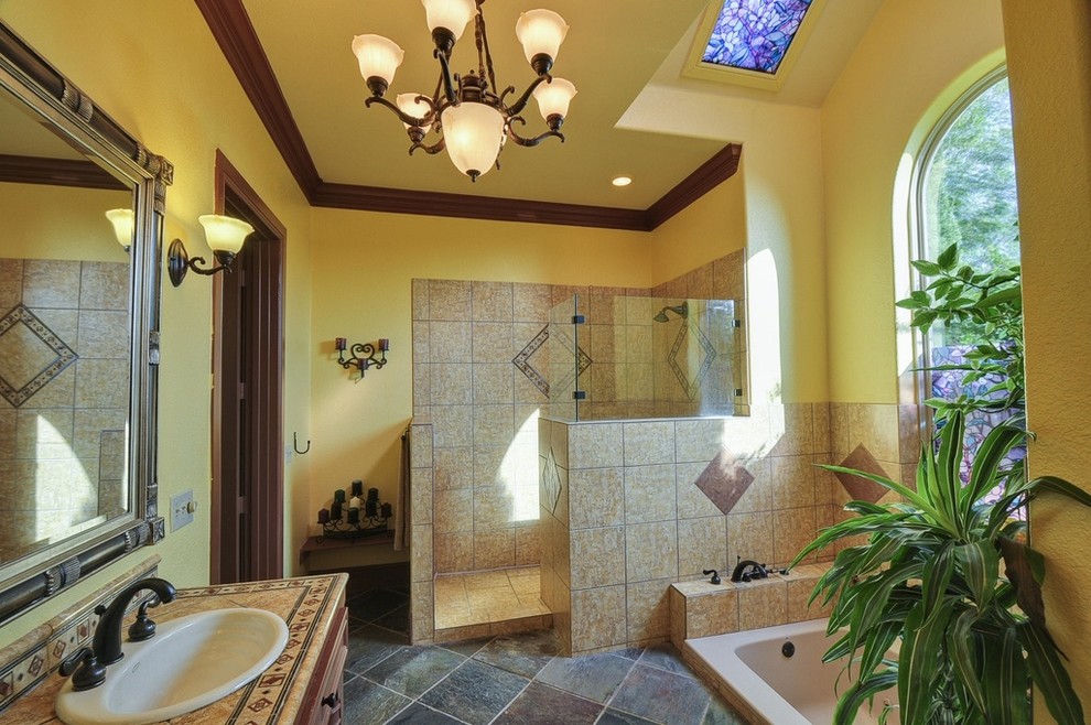 Foto de cuarto de baño principal clásico con bañera encastrada, ducha abierta, paredes amarillas, suelo de pizarra, lavabo encastrado y ducha abierta
