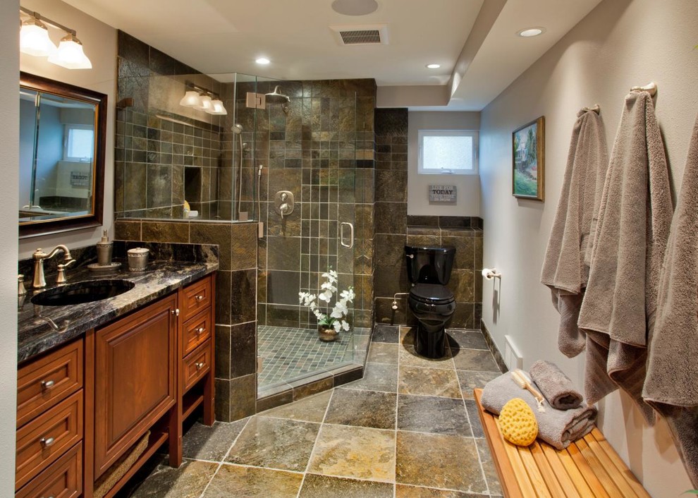 Foto på ett rustikt badrum, med luckor med infälld panel, skåp i mellenmörkt trä, en dusch i en alkov, skifferkakel, beige väggar, skiffergolv, ett undermonterad handfat, granitbänkskiva och dusch med gångjärnsdörr