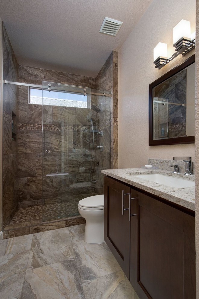 This is an example of a large traditional shower room bathroom in Phoenix with shaker cabinets, dark wood cabinets, an alcove shower, brown tiles, porcelain tiles, beige walls, porcelain flooring, a submerged sink, granite worktops, multi-coloured floors and a sliding door.