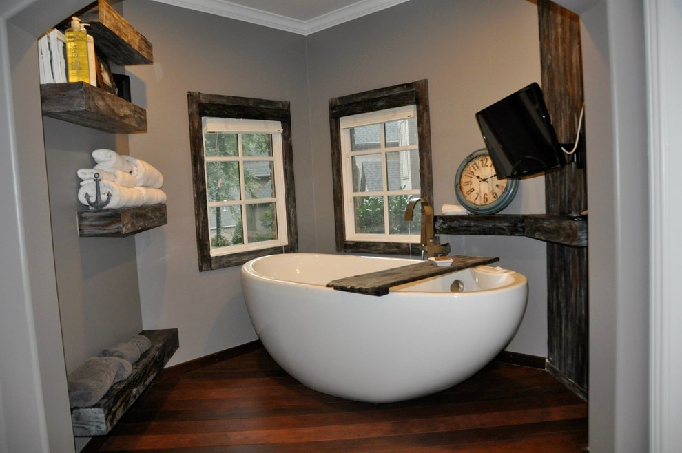 Bild på ett stort amerikanskt en-suite badrum, med luckor med upphöjd panel, grå skåp, ett fristående badkar, en hörndusch, grå väggar, laminatgolv, ett fristående handfat och bänkskiva i täljsten