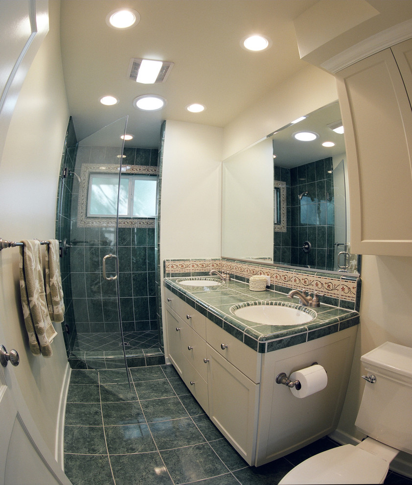 Bild på ett stort vintage en-suite badrum, med ett undermonterad handfat, släta luckor, beige skåp, kaklad bänkskiva, en dusch i en alkov, en toalettstol med hel cisternkåpa, flerfärgad kakel och beige väggar
