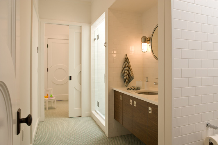 Mittelgroßes Modernes Badezimmer mit flächenbündigen Schrankfronten, dunklen Holzschränken, weißen Fliesen, Metrofliesen, Mosaik-Bodenfliesen, Unterbauwaschbecken, Mineralwerkstoff-Waschtisch, grünem Boden und weißer Wandfarbe in New York