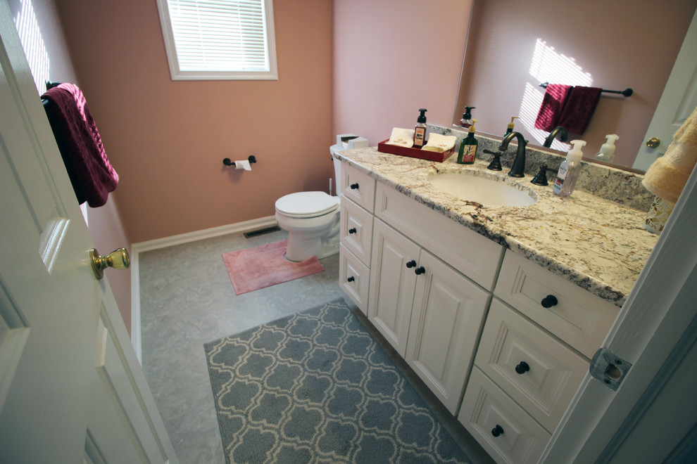 Idee per una stanza da bagno chic di medie dimensioni con ante con bugna sagomata, ante bianche e top in granito