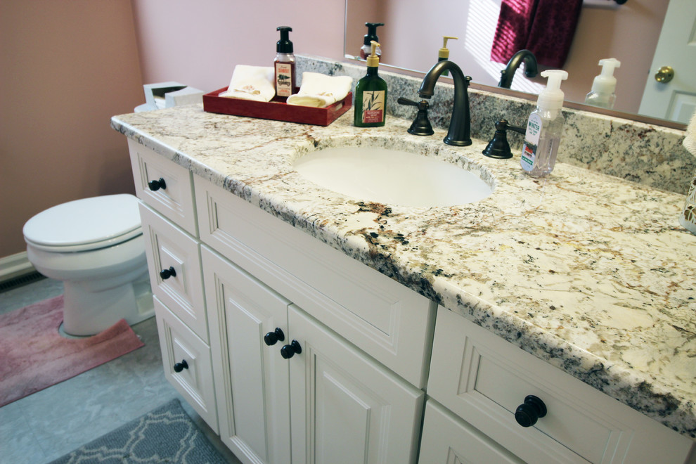 Klassisk inredning av ett mellanstort badrum, med luckor med upphöjd panel, vita skåp och granitbänkskiva