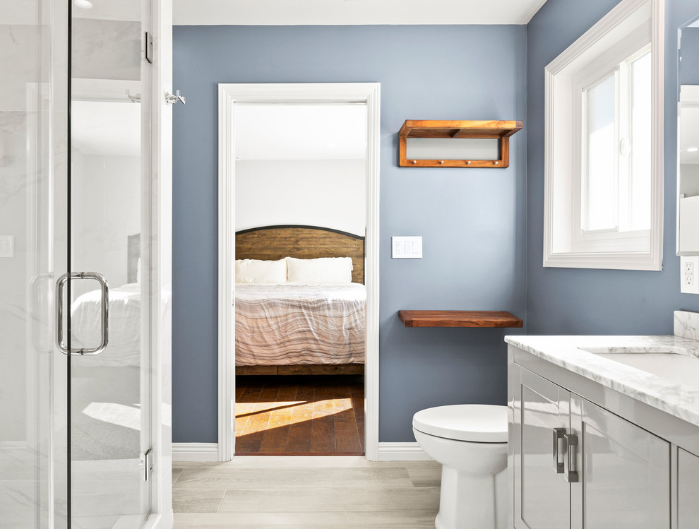 Modelo de cuarto de baño principal clásico renovado grande con armarios estilo shaker, puertas de armario grises, baldosas y/o azulejos blancos, baldosas y/o azulejos de porcelana, paredes azules, suelo de baldosas de porcelana, encimera de mármol y suelo gris