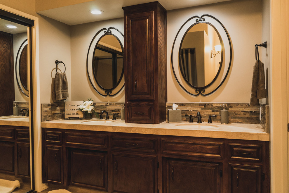 На фото: главная ванная комната среднего размера с фасадами с выступающей филенкой, темными деревянными фасадами, коричневой плиткой, удлиненной плиткой, коричневыми стенами и врезной раковиной с
