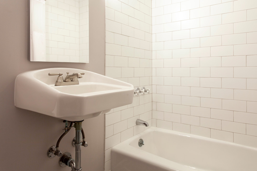 Réalisation d'une salle d'eau tradition de taille moyenne avec une baignoire en alcôve, WC à poser, un carrelage blanc, un carrelage métro, un mur gris, un sol en marbre, un lavabo suspendu et un sol jaune.