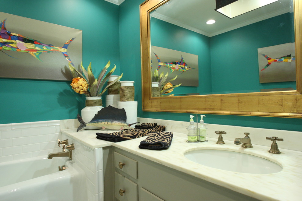 Cette photo montre une salle de bain exotique de taille moyenne avec un lavabo posé, une baignoire en alcôve, WC à poser, un placard à porte plane, des portes de placard grises, un plan de toilette en marbre, un carrelage blanc, un carrelage métro, un mur bleu et un sol en marbre.