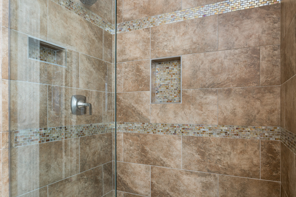Стильный дизайн: главная ванная комната среднего размера в современном стиле с фасадами с филенкой типа жалюзи, коричневыми фасадами, угловой ванной, душем в нише, унитазом-моноблоком, разноцветной плиткой, плиткой мозаикой, бежевыми стенами, полом из керамогранита, монолитной раковиной, мраморной столешницей, бежевым полом и душем с распашными дверями - последний тренд