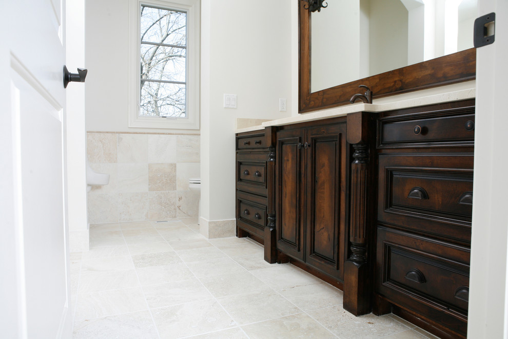 Immagine di una grande stanza da bagno padronale con lavabo rettangolare, ante con bugna sagomata, ante in legno bruno, top in marmo, piastrelle beige, piastrelle in pietra, pareti bianche e pavimento in travertino