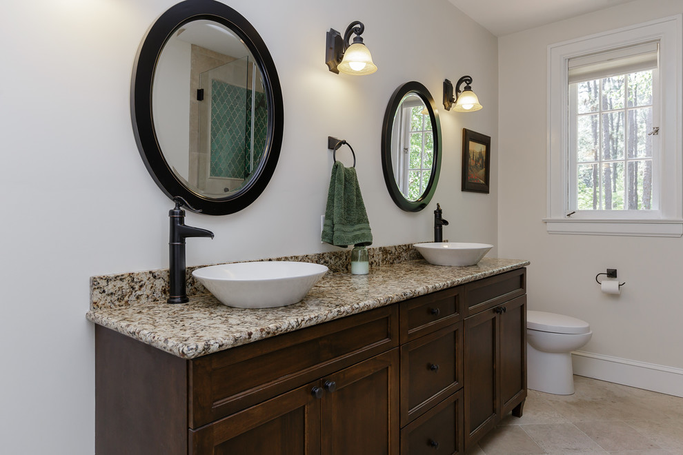 Medium sized traditional ensuite bathroom in Raleigh with shaker cabinets, dark wood cabinets, a corner shower, beige tiles, beige walls, a vessel sink, granite worktops, ceramic tiles and ceramic flooring.
