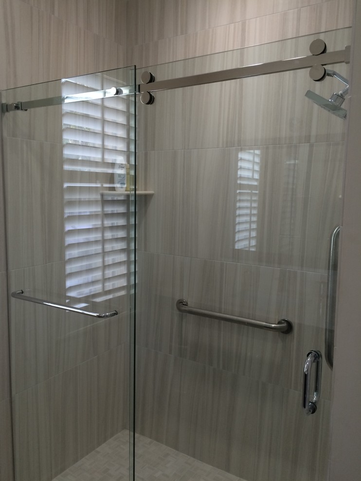 На фото: ванная комната среднего размера в современном стиле с душем в нише, серой плиткой, керамической плиткой, серыми стенами, полом из керамической плитки, серым полом и душем с раздвижными дверями
