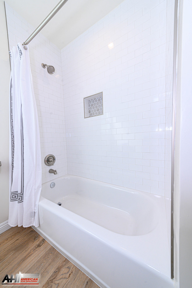ロサンゼルスにある低価格の小さなトラディショナルスタイルのおしゃれな浴室 (シェーカースタイル扉のキャビネット、白いキャビネット、アンダーマウント型浴槽、シャワー付き浴槽	、一体型トイレ	、白いタイル、サブウェイタイル、白い壁、無垢フローリング、オーバーカウンターシンク、珪岩の洗面台、ベージュの床、グレーの洗面カウンター) の写真